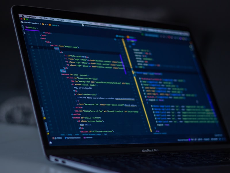 Developer workspace with HTML, CSS, and JavaScript code on screen while building a responsive web page